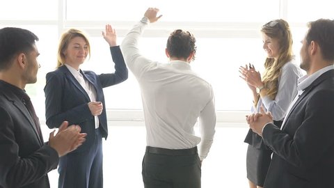group of businessman's celebrating a success. the man give a high five to a colleague. slow motion