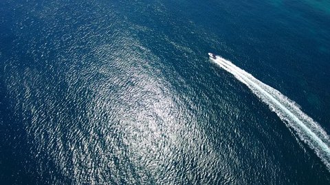 Aerial drone 4k cinematic footage. Flying above speeding boat on the blue sea. 