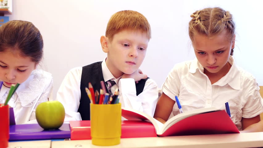 Serious children writing task in the school. dolly shot. 