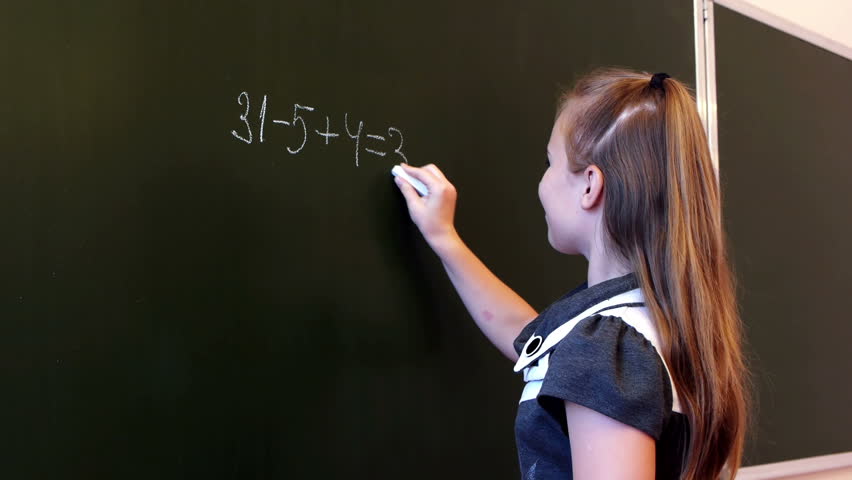 Adorable schoolgirl writing mathematic expression