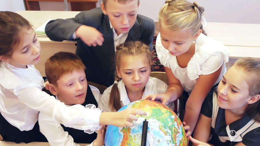 Happy schoolchildren searching country on the globe