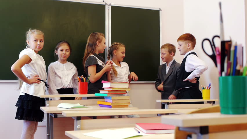 Schoolchildren standing near the blackboard and chatting