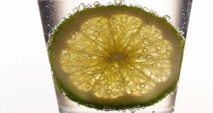 Slice of Green Citrus, citrus aurantifolia, in a Glass, Real Time 4K