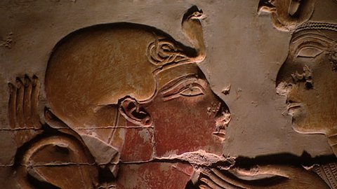 ABYDOS, EGYPT - CIRCA 2002: Zoom-out from the head of 19th Dynasty Pharaoh Seti I looking at the goddess Isis to reveal her sun-disc-in-horns head-dress. Temple of Abydos.