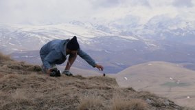 Traveler sets action camera for takes pictures of the mouintains landscape. Man taking photo at beautiful rocky place with action camera and professional DSLR camera.