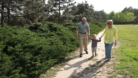 Grandparents lifting up toddler boy outdoor