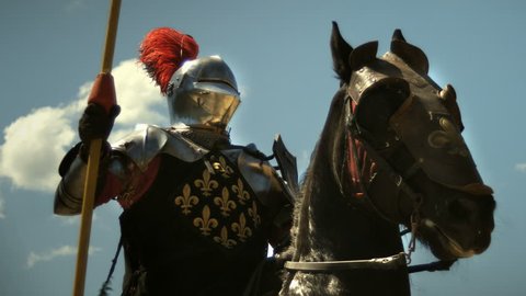 Medieval knight with lance riding horse to joust tournament