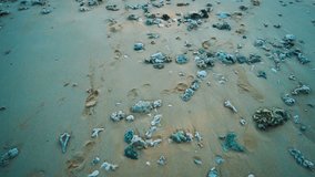 Drone flyover sandy beach with rocks and sea over beautiful summer sky - video in slow motion