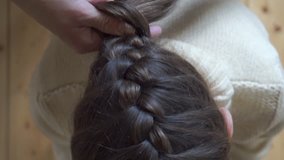 Mother braids daughter pigtail, top view hd video