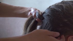 Mother braids daughter pigtail, close up hd video