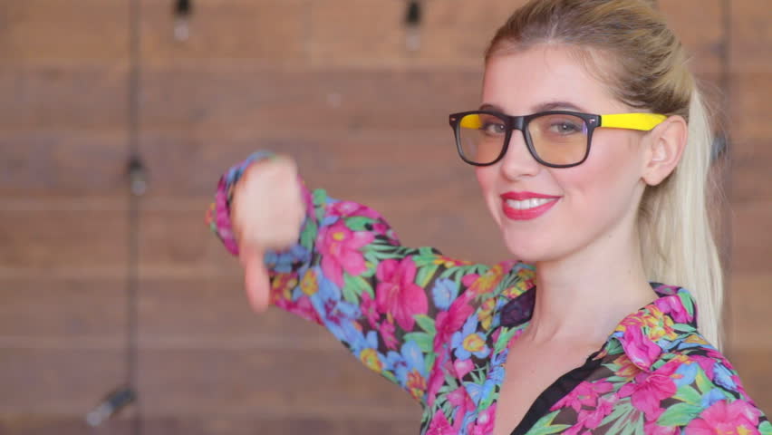 Thumbs down by attractive young women in glasses