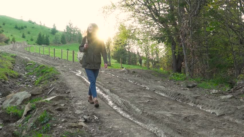 Girl with backpack on the thaw hill.