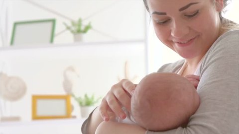 Breast feeding, breastfeeding concept. Young happy Mother feeding her Newborn baby. mother breastfeeding, hugging and kissing her hew born child. Lactation infant concept. 4K UHD video. Slow motion
