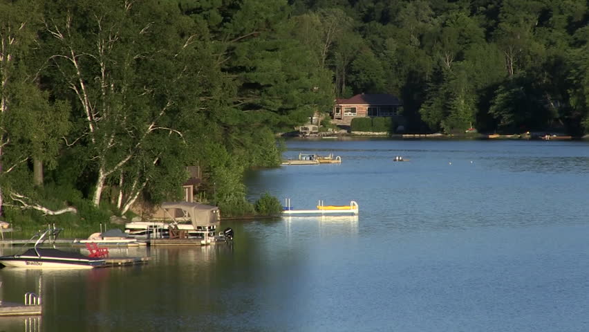 Summer evening: Boats and docks on a calm lake in Quebec, Canada