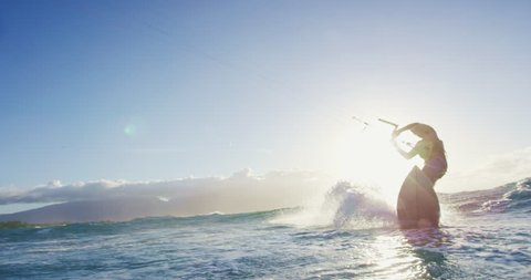 Young man kite surfing in blue ocean at sunset. Extreme sports summer. Shot on RED in 4k
