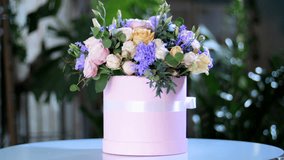 Flower bouquet in the rays of light, rotation, the floral composition consists Rose of avalanche, Rose pion-shaped, Carnation, Eustoma, solidago, eucalyptus, Hiperikum