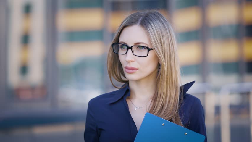 Portrait of a beautiful and young woman, who probably works as a secretary, she expects the boss to give him important documents