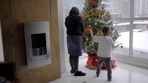 Grand mother and kid decorating christmas tree inside modern condominium toronto