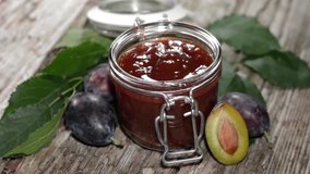 Plum Jam in a glass on wooden background
