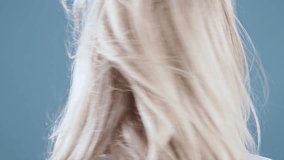 Elegant blonde woman posing on blue background, 4k slow motion clip