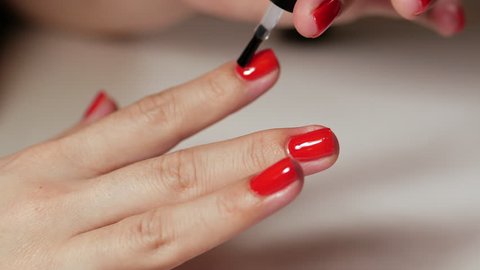Female hands manicure with red nails close up view on white background. Classic color manicure.