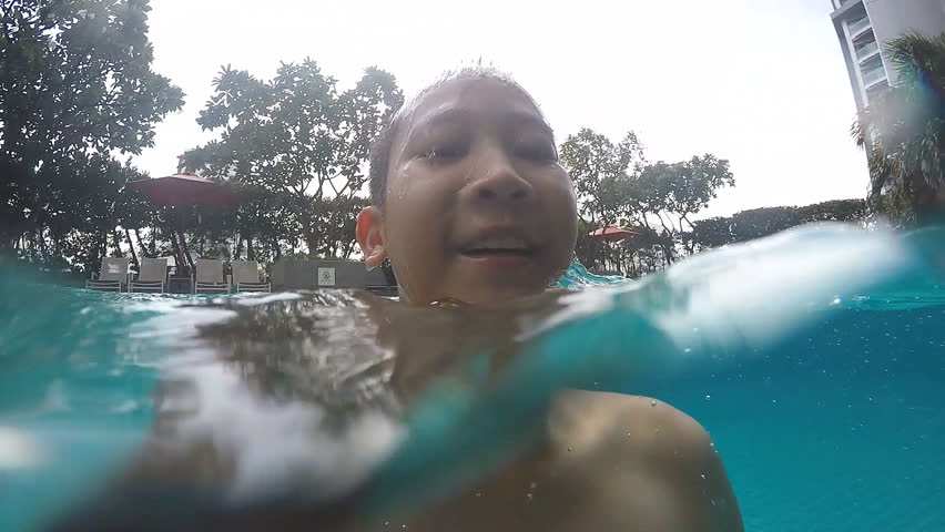 Happy active child in the swimming pool, underwater  view
