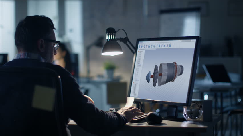 Late at Night in the Office. Design Engineer Works on His Personal Computer. On His Display We See Blueprints. Office Looks Modern. In the Background People Working.  Royalty-Free Stock Footage #27466381