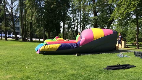 Warsaw,Poland.4 June 2017. Inflatable bounce house water slide in the park.   Filling with air. Time lapse. 