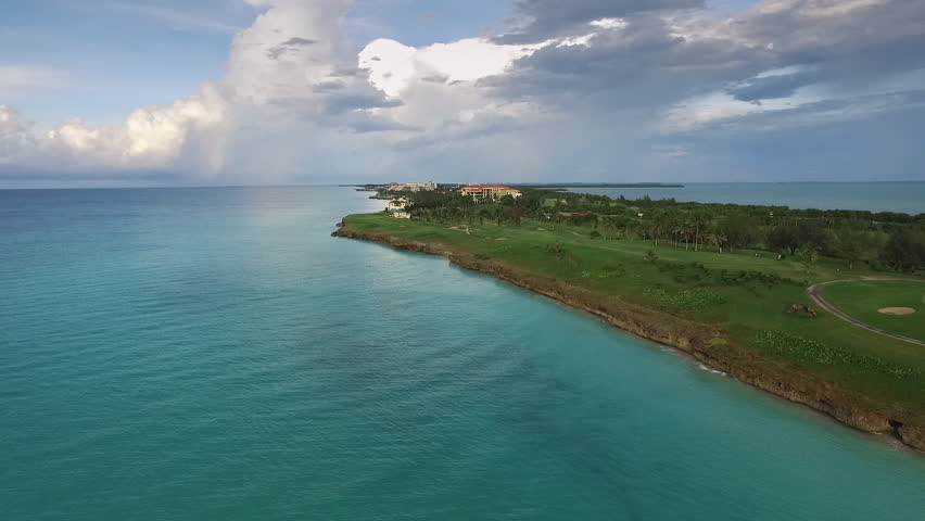 Drone flying over Varadero, Cuba: golf course. Aerial view of Cuban beach. Landscape seen from the sky with clouds and ocean. International travel destinations for tourists, holiday and vacation