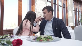 Couple in love at the restaurant drinks a red wine for brotherhood and kisses slow motion stock footage video
