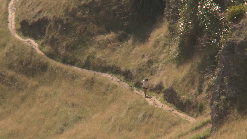 A runner on a steep and hilly country track