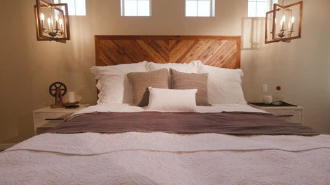 Move Over Front of Bed in Modern Bedroom. shot moves over the front of a bed toward the headboard and pillows
