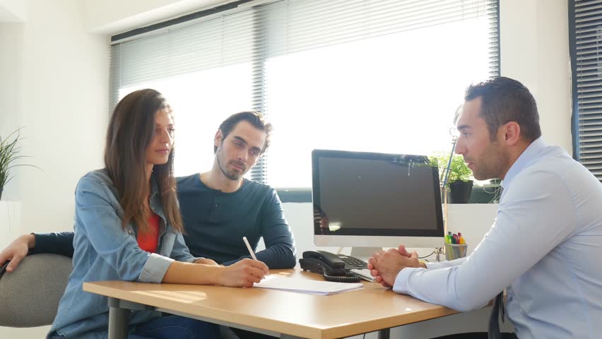 Happy young couple in office shaking hands with businessman on a business buying agreement contract signature  | Shutterstock HD Video #27478309