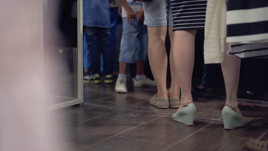 The queue of people standing in the cash department of the clothing department in the supermarket.  Royalty-Free Stock Footage #27479797