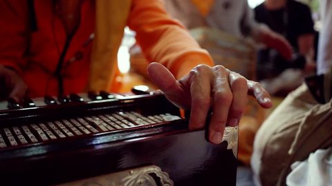 The performance of the kirtan of the hare Krishna in the Krishna temple on the ancient classical instruments. Big game plan the harmonium.