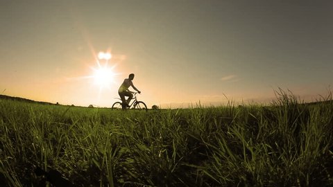 Man rides his bike at sunset
