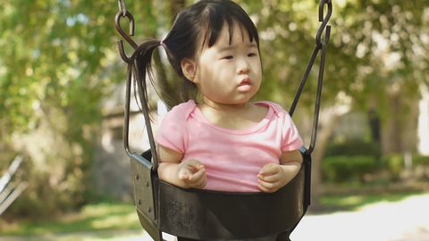 Beautiful baby asian toddler girl in swing