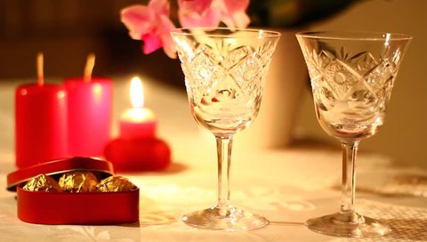 A beautiful evening for two with present, candles and glasses for drink.