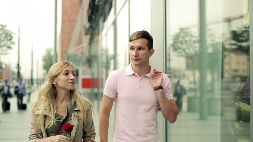 Young couple talking and looking at shop window