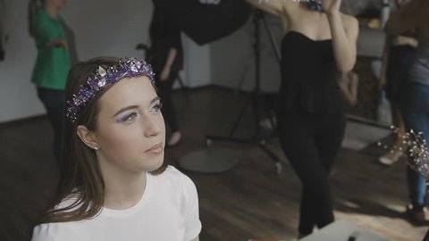 Make-up artist makes a professional make-up for a very beautiful girl in a photo studio