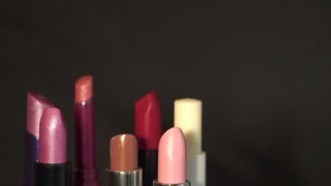 Multicolored lipsticks. Rotates. On a black background