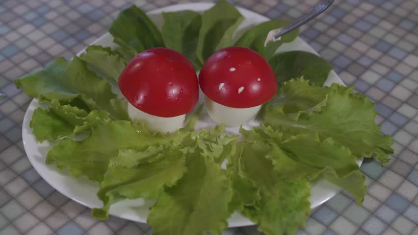 Close Up,plug Tip Carefully Applied Dots With Mayonnaise on Tomato Halves,lying on Top of the Egg Surrounded by Fresh Lettuce,imitating the Mushroom Caps of the Fly Agaric on White Figural Plate