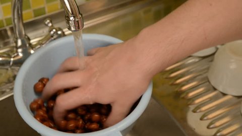 Wash the nuts in the colander in the kitchen.