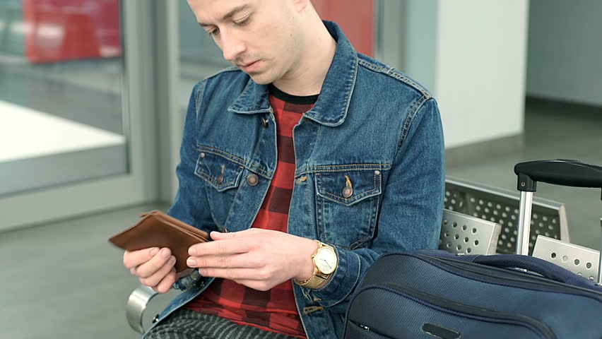 Man looks worried while checking his wallet on the train station, steadycam shot Royalty-Free Stock Footage #27519700
