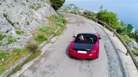 red sport convertible car moving in Amalfi coast