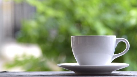Steaming coffee cup on a rainy day