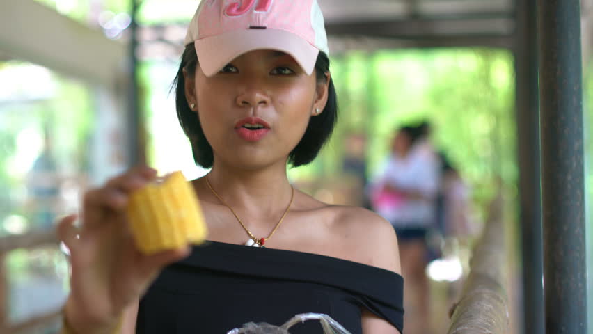 Happy young asian girl holds raw corn 4k UHD (3840x2160)