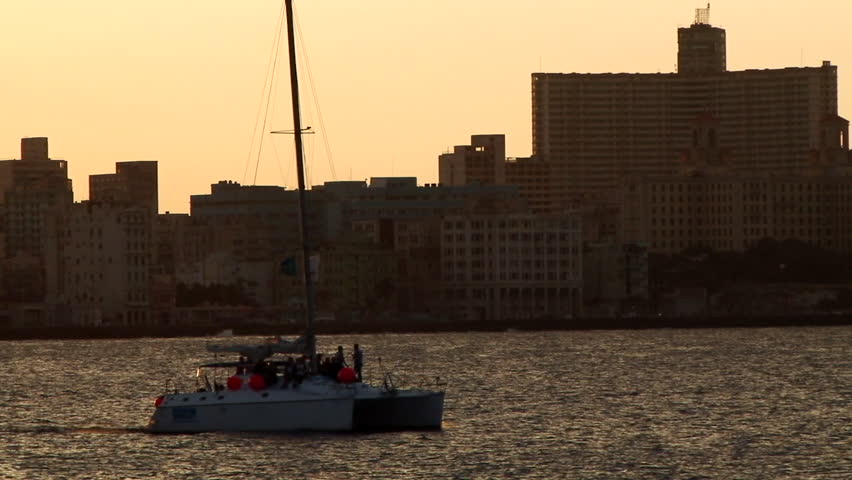 Catamaran sailing with people on board in the bay of Havana in Cuba. Taken during sunset