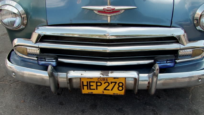 Tilt up of old classic rusty American car at Plaza 13 de Marzo in Havana, Cuba