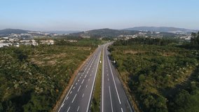 Traffic on Highway Crossing Green Fields With blue Sky in the Background, Aerial Footage
